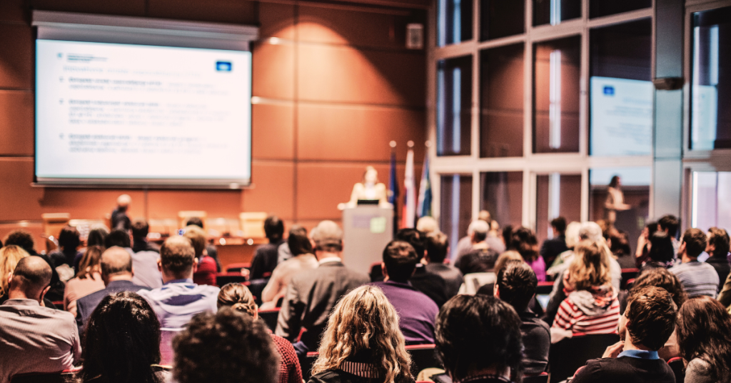 Conference presentation with audience attendees for event marketing and promotional products